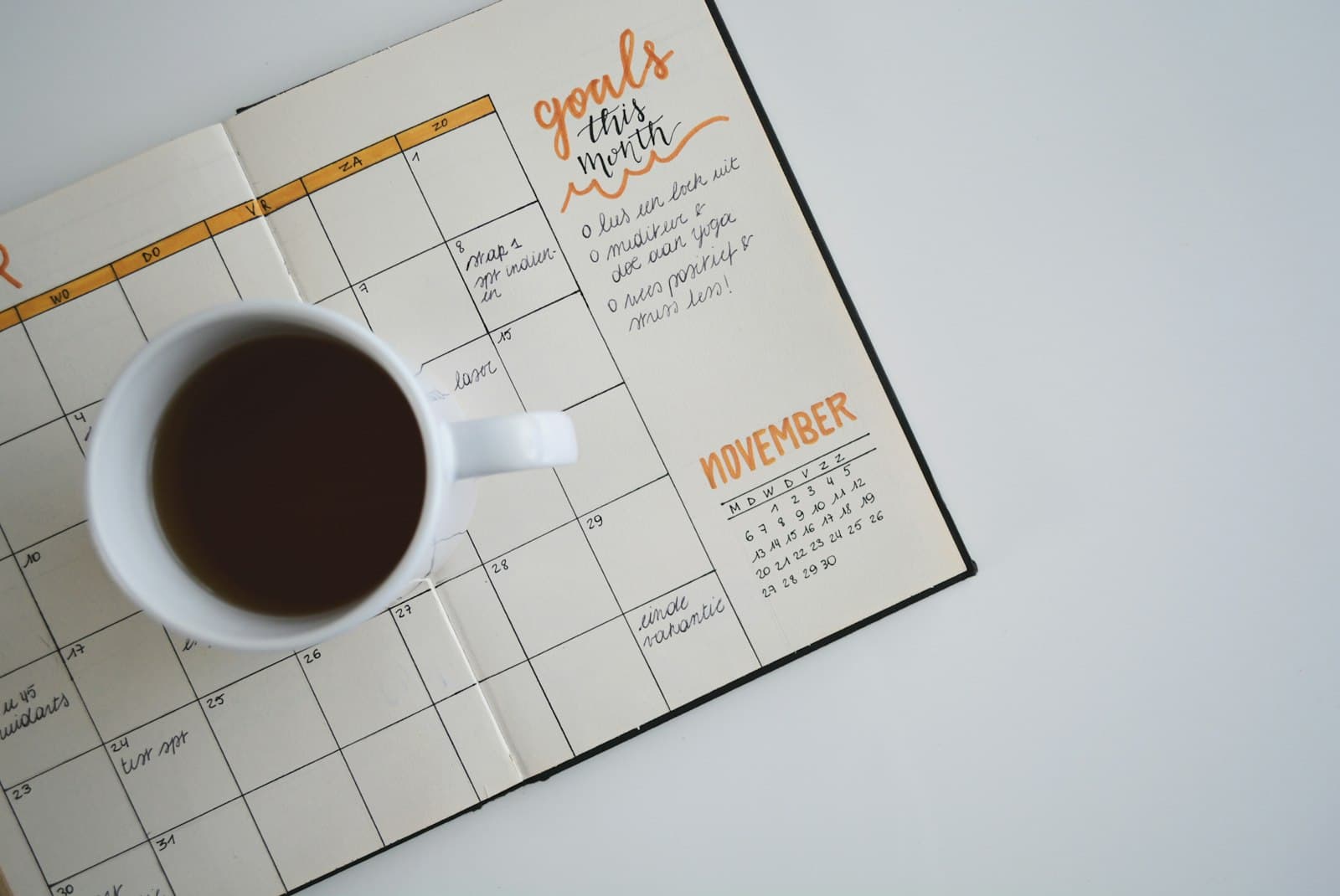Agenda en papel con planificación mensual y taza de café: organizar la agenda de una consulta psicológica