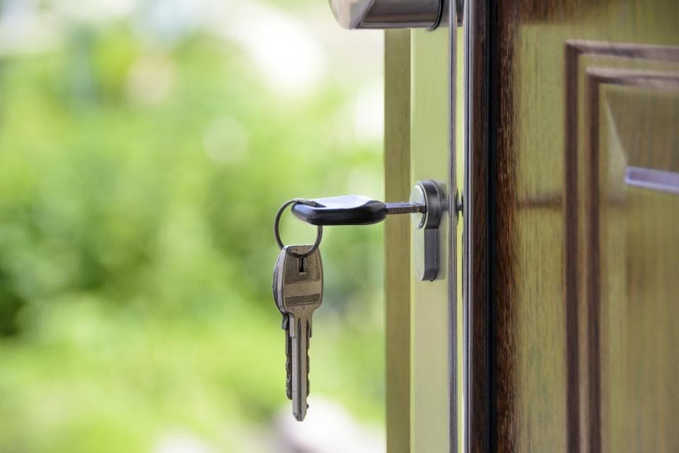 Una llave puesta en la cerradura de una puerta entreabierta que da a un jardín: salir de una plataforma llevándote lo tuyo